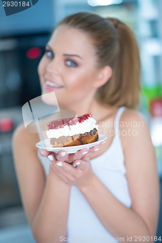 Image of Young woman holding a berry and cream cake