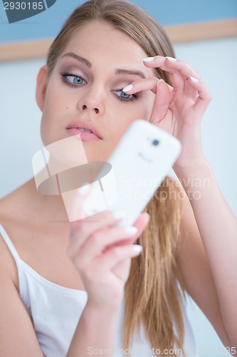 Image of Beautiful girl fixing her eye lashes