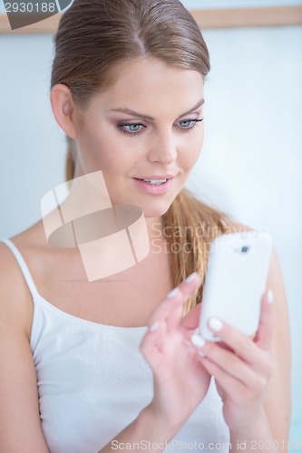 Image of Young woman reading a text message on her mobile