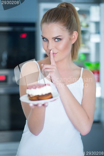 Image of Guilty young woman preparing to eat a cake