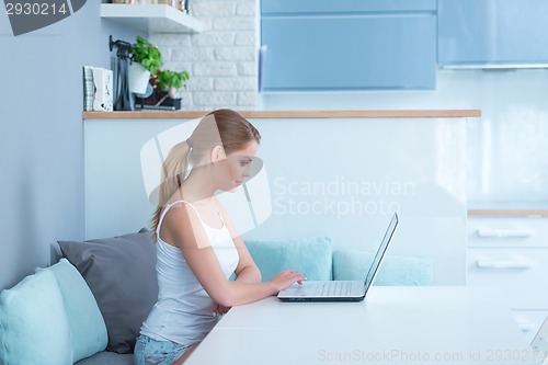 Image of Young woman sitting working at home