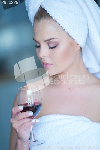 Image of Woman in Bath Towel Looking Down at Glass of Wine