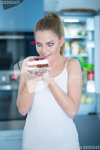 Image of Young woman holding a berry and cream cake