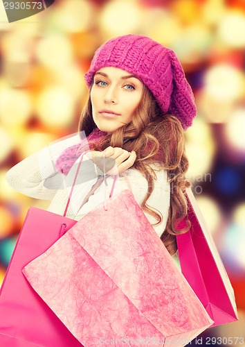 Image of woman in winter clothes with pink shopping bags