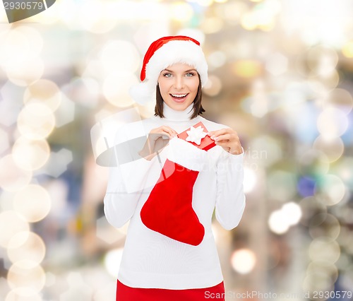 Image of woman in santa hat with gift box and stocking