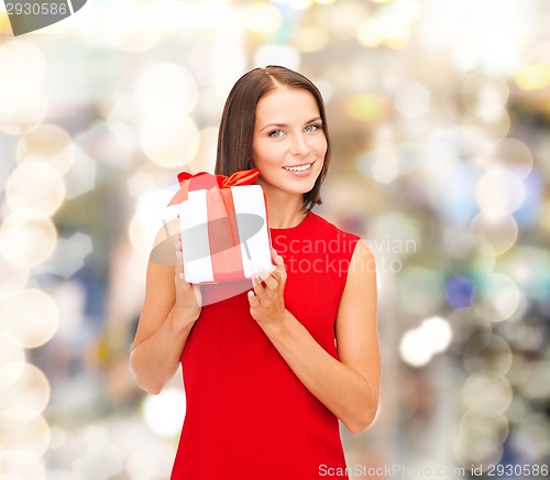 Image of smiling woman in red dress with gift box