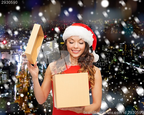 Image of smiling woman in santa helper hat with gift box