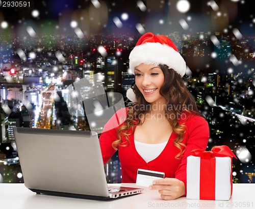 Image of smiling woman with credit card and laptop