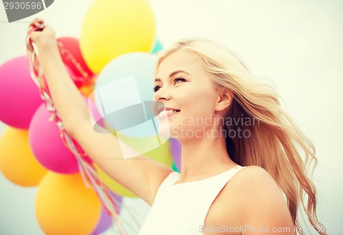 Image of woman with colorful balloons outside