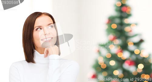 Image of thinking and smiling woman in white sweater