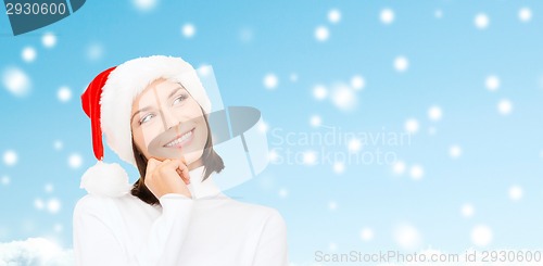 Image of thinking and smiling woman in santa helper hat