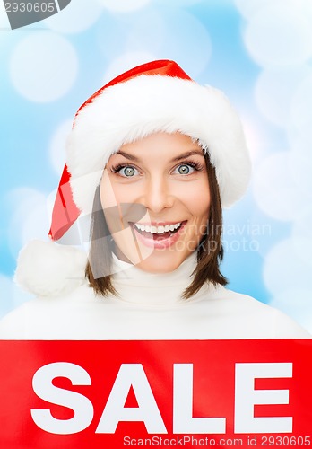 Image of smiling woman in santa helper hat with sale sign