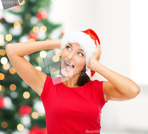 Image of surprised woman in santa helper hat