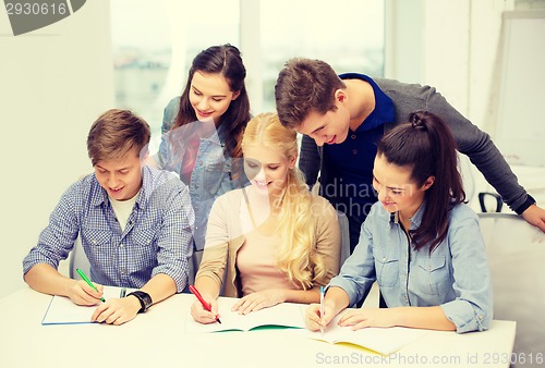 Image of smiling students with notebooks at school