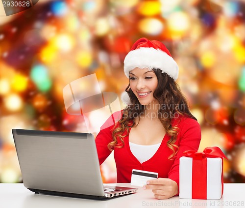 Image of smiling woman with credit card and laptop