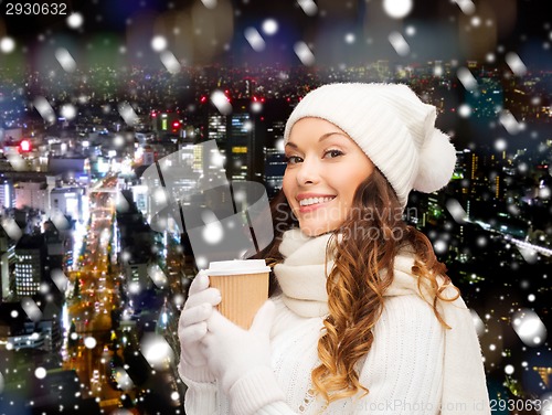 Image of smiling young woman in winter clothes with cup