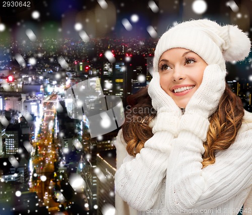 Image of smiling young woman in white winter clothes