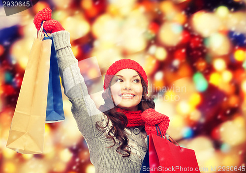 Image of asian woman in winter clothes with shopping bags
