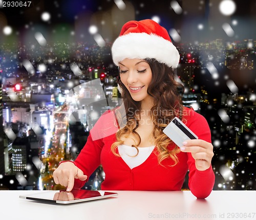 Image of smiling woman with credit card and tablet pc