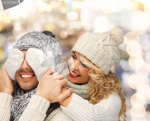 Image of smiling couple in sweaters and santa helper hats