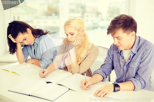 Image of tired students with notebooks at school