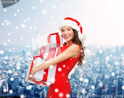 Image of smiling woman in santa helper hat with gift box