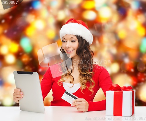 Image of smiling woman with credit card and tablet pc