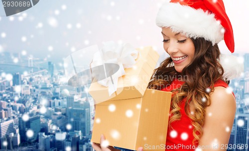 Image of smiling woman in santa helper hat with gift box