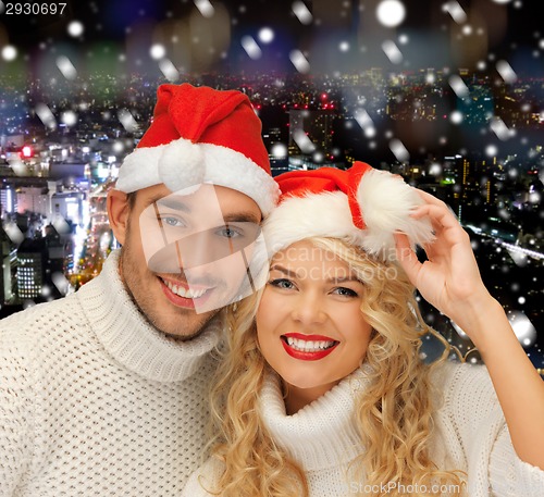 Image of smiiling couple in sweaters and santa helper hats