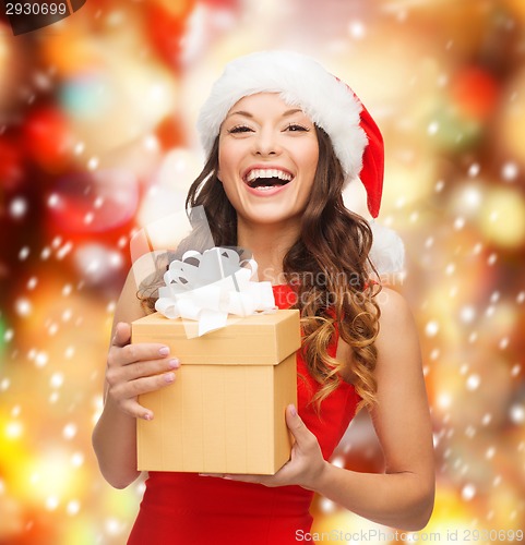 Image of smiling woman in santa helper hat with gift box