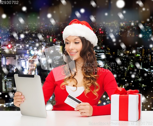 Image of smiling woman with credit card and tablet pc