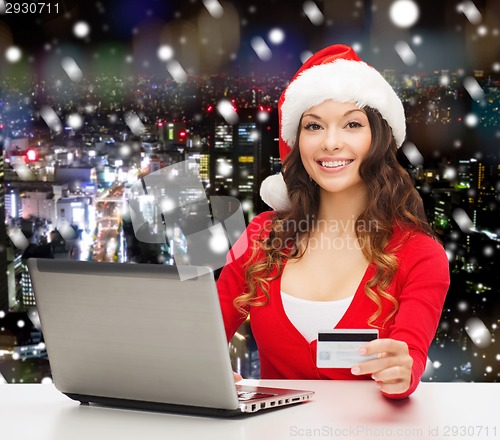 Image of smiling woman with credit card and laptop