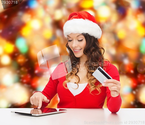 Image of smiling woman with credit card and tablet pc