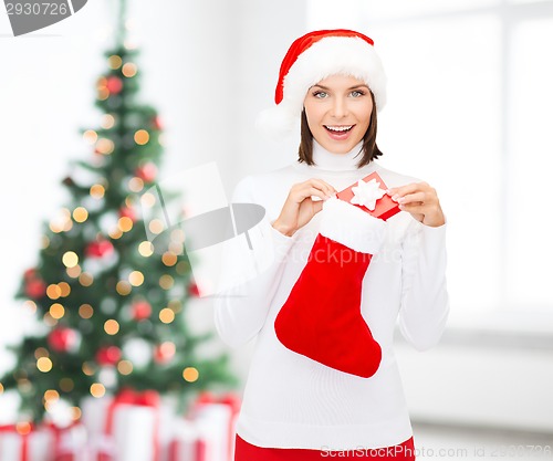 Image of woman in santa hat with gift box and stocking