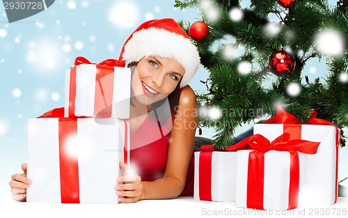 Image of smiling woman in santa helper hat with gift boxes