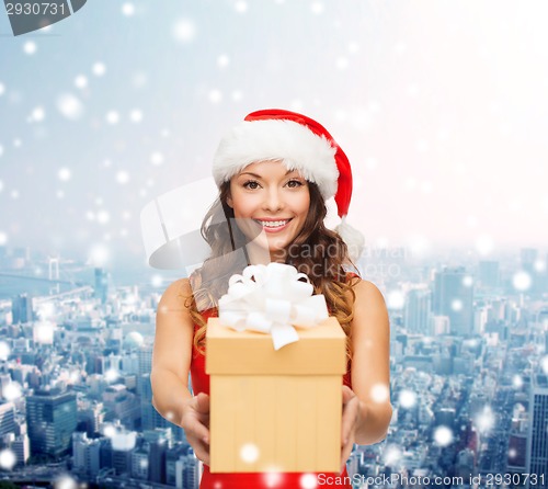 Image of smiling woman in santa helper hat with gift box