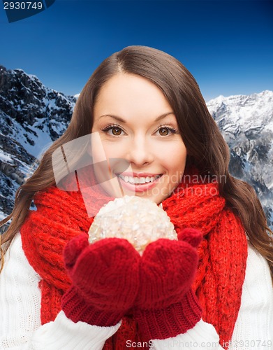 Image of smiling woman in winter clothes with snowball