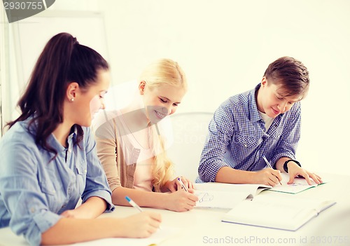 Image of smiling students with notebooks at school