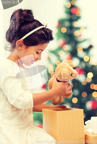 Image of happy child girl with gift box and teddy bear