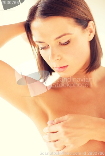 Image of woman checking breast for signs of cancer