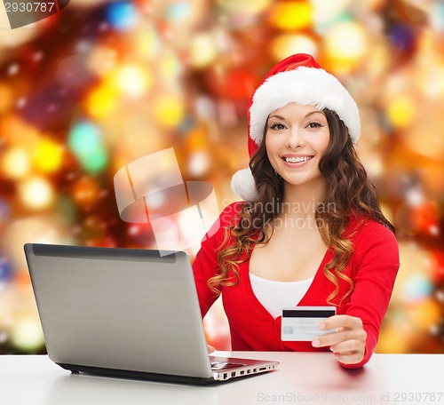 Image of smiling woman with credit card and laptop