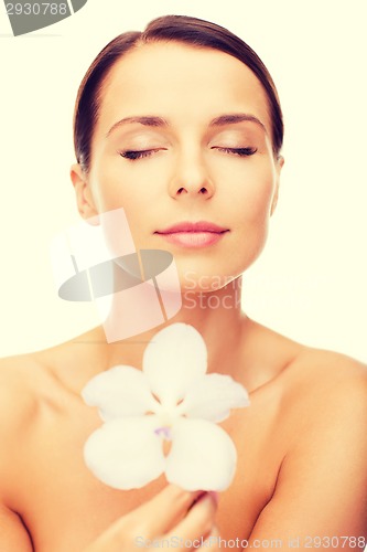 Image of relaxed woman with orhid flower