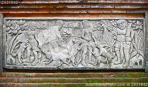 Image of Images of people and dogs carved on a stone plate. Indonesia, Ba