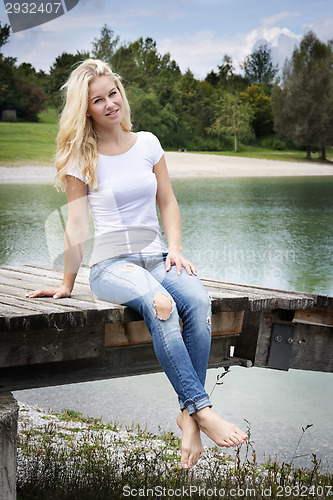 Image of Blond woman sitting on a jetty