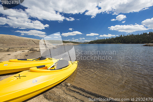 Image of Pair of Yellow Kayaks on Beautiful Mountain Lake Shore.