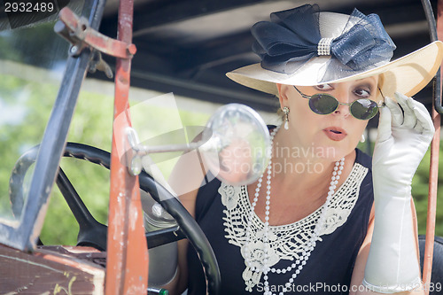 Image of Attractive Woman in Twenties Outfit Checking Makeup in Antique A