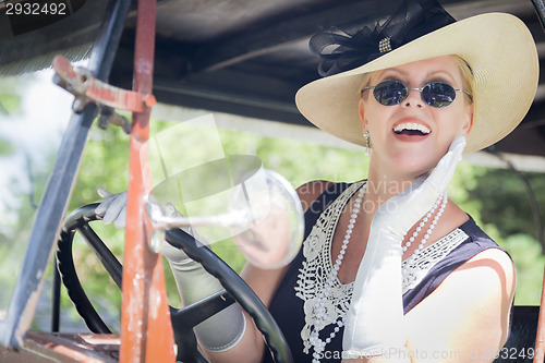 Image of Attractive Woman in Twenties Outfit Driving an Antique Automobil