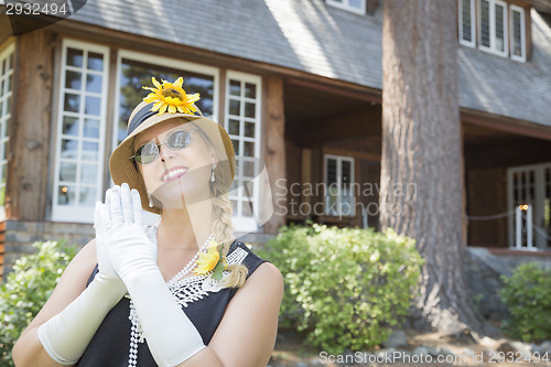 Image of Attractive Woman in Twenties Outfit Near Antique House