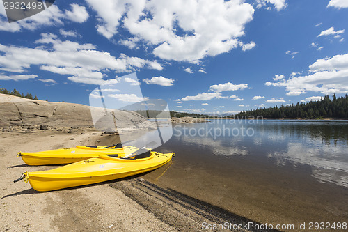 Image of Pair of Yellow Kayaks on Beautiful Mountain Lake Shore.