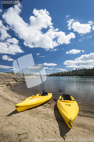 Image of Pair of Yellow Kayaks on Beautiful Mountain Lake Shore.